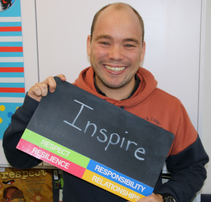 Image of Justin holding a sign saying inspire